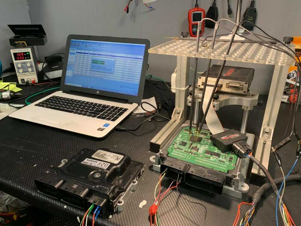 Installation de test électronique avec un ordinateur portable connecté à des circuits imprimés et à du matériel de mesure.
