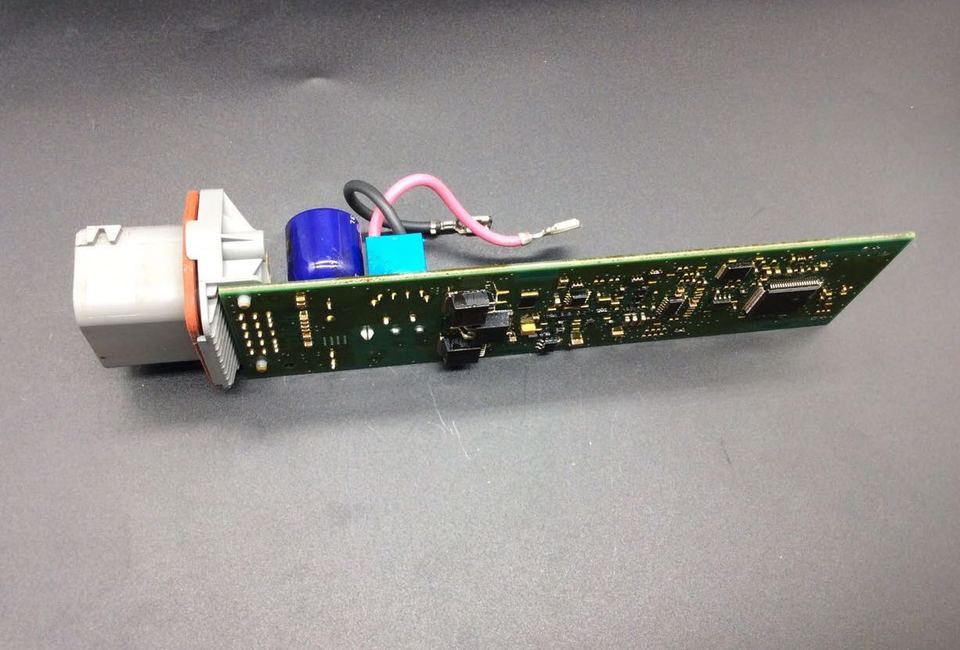 Circuit imprimé avec des composants électroniques et un connecteur blanc monté à une extrémité.